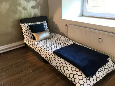 a small bed sitting under a window with a pillow at Jure apartment in Ljubljana in Ljubljana