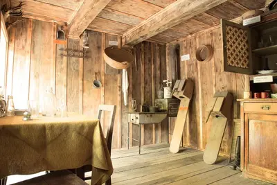a dining room with a table and wooden walls at Lake Peak Apartments, Ribniško Pohorje in Ribnica na Pohorju