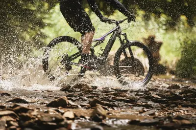 a person riding a bike through the water at Lake Peak Apartments, Ribniško Pohorje in Ribnica na Pohorju