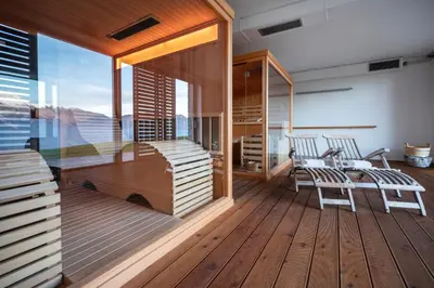 a room with a balcony with a table and chairs at Nebesa Chalets in Kobarid