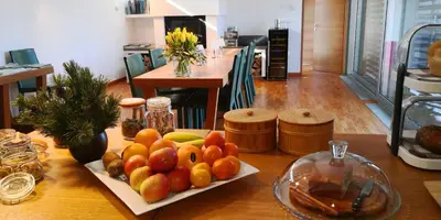 a table with a plate of fruit on it at Nebesa Chalets in Kobarid