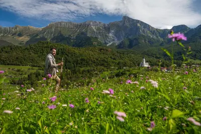 a man standing in a field of flowers at Nebesa Chalets in Kobarid