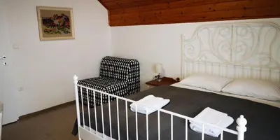 a bedroom with a white bed and a chair at Vas Lipa 8 - 36 in Podčetrtek