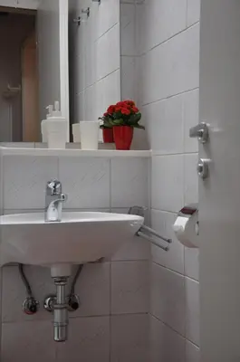 a white bathroom with a sink and a mirror at Vas Lipa 8 - 36 in Podčetrtek