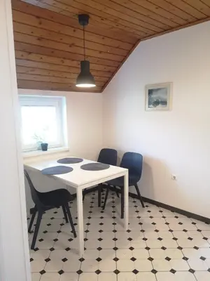 a dining room with a white table and chairs at Vas Lipa 8 - 36 in Podčetrtek