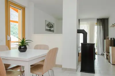 a white dining room with a white table and chairs at Apartma Fani-Kobarid in Podbela