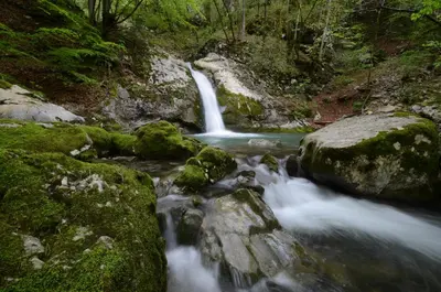 a waterfall in the middle of a river with rocks at Apartma Fani-Kobarid in Podbela