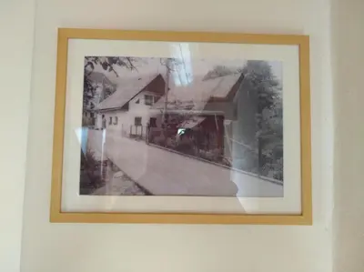 a picture of a house hanging on a wall at Apartma Pr Martin in Begunje na Gorenjskem