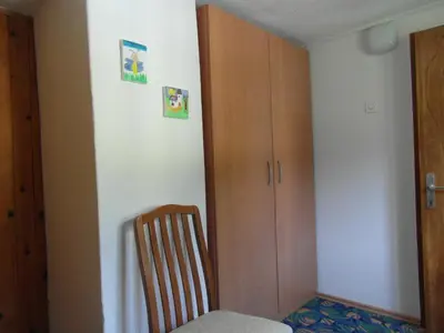a room with a wooden cabinet and a chair at Apartma Pr Martin in Begunje na Gorenjskem