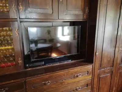 a flat screen tv in a wooden cabinet at Apartma Pr Martin in Begunje na Gorenjskem