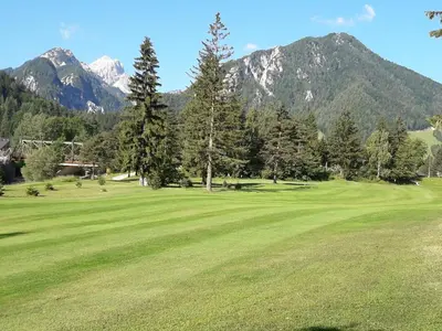 a view of a golf course with mountains in the background at Apartma BaLe in Kranjska Gora