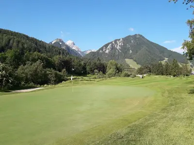 a view of a golf course with mountains in the background at Apartma BaLe in Kranjska Gora