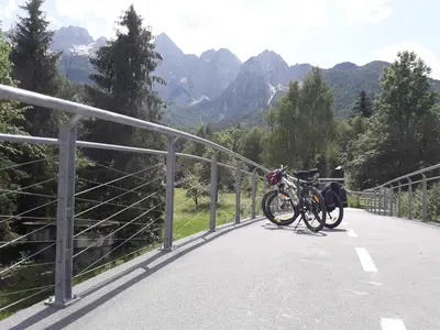 a bike parked on a bridge with mountains in the background at Apartma BaLe in Kranjska Gora