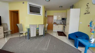 a living room with a table and chairs and a kitchen at Apartma BaLe in Kranjska Gora