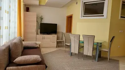 a living room with a table and chairs and a television at Apartma BaLe in Kranjska Gora