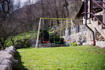 two swings in a yard next to a building at Apartmaji Berginc in Kobarid