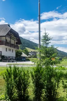 a building with a pole in front of a street at Nika & Erik in Kranjska Gora