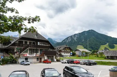 a town with cars parked in a parking lot with mountains at Nika & Erik in Kranjska Gora