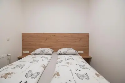 a bed with a wooden headboard and two pillows at Nika & Erik in Kranjska Gora