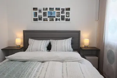 a bedroom with a bed with two lamps on two tables at Elegant central Apt Maribor w/Parking in Maribor