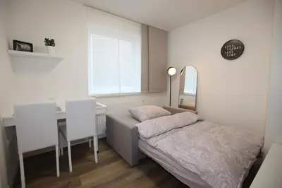 a bedroom with a bed and a desk and a mirror at Elegant central Apt Maribor w/Parking in Maribor