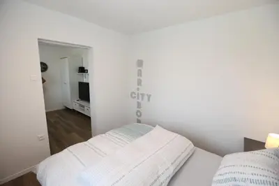 a white bedroom with a bed and a mirror at Elegant central Apt Maribor w/Parking in Maribor