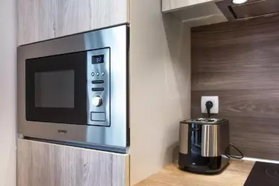 a microwave on a wall next to a coffee maker at ★ Exclusive Central Apartment ★ FREE Garage ★ in Ljubljana
