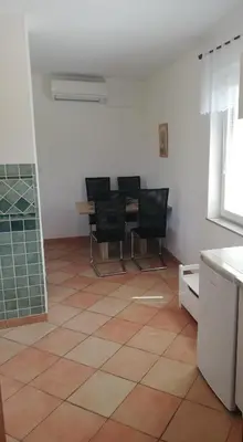 a kitchen with black chairs and a tiled floor at Apartment Antonia in Dobova