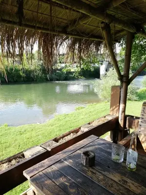 a wooden table sitting next to a river at Apartment Antonia in Dobova