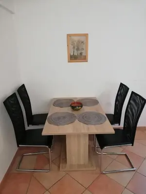 a dining room table with four chairs around it at Apartment Antonia in Dobova