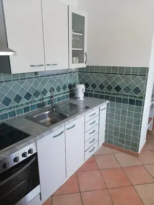 a kitchen with white cabinets and a sink at Apartment Antonia in Dobova