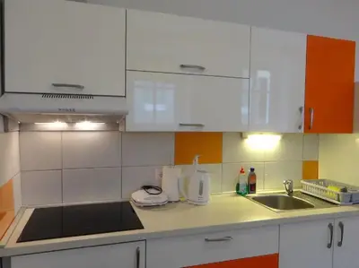 a kitchen with white cabinets and a sink at Apartments FABRKA in Ljubljana