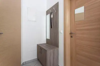 a bathroom with a mirror and a wooden door at Apartments FABRKA in Ljubljana