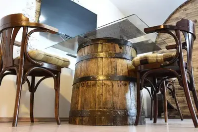 a wooden barrel sitting next to two chairs at Apartments FABRKA in Ljubljana
