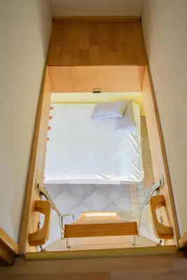 a small bed in a small room with a bench at Holiday Home Dobrotin in Vojnik
