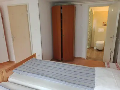 a bedroom with a bed and a closet and a bathroom at Sobe Černilogar in Tolmin