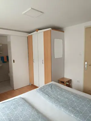 an empty room with a bed and a closet at Sobe Černilogar in Tolmin