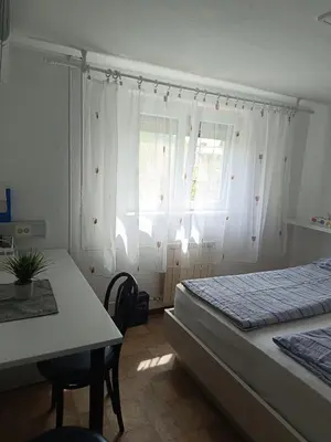 a bedroom with a bed and a table and window at Sobe Černilogar in Tolmin
