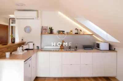 a kitchen with white cabinets and a sink at HOMe apartments & Yoga studio in Bled-Rečica
