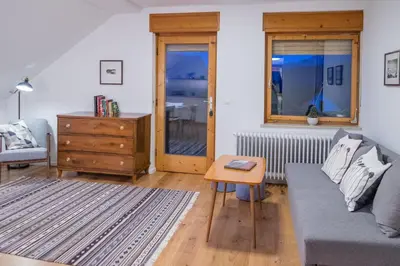 a living room with a couch and a table at HOMe apartments & Yoga studio in Bled-Rečica