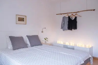 a bedroom with a bed with a white comforter and lights at HOMe apartments & Yoga studio in Bled-Rečica