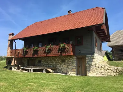 a building with a balcony with plants on it at Sunny House with Sauna in Bistrica ob Sotli