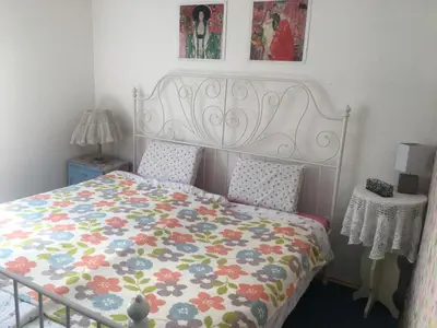 a bedroom with a bed with a floral comforter at Blue Cottage in Podvrh
