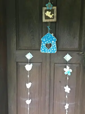 a door with four cloud ornaments hanging on it at Blue Cottage in Podvrh