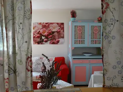 a kitchen with a red chair and a blue cabinet at Blue Cottage in Podvrh