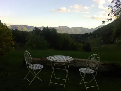 two chairs and a table with a view of mountains at Blue Cottage in Podvrh