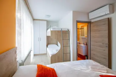a small bedroom with a bed and a bathroom at Rooms Šajina in Podgrad