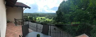 a balcony with a view of a green field at Rooms Šajina in Podgrad