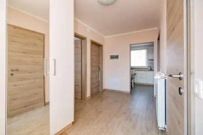 a hallway with wooden floors and a door at Rooms Šajina in Podgrad