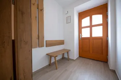 a hallway with a wooden door and a bench at Hiša Urška in Log pod Mangartom